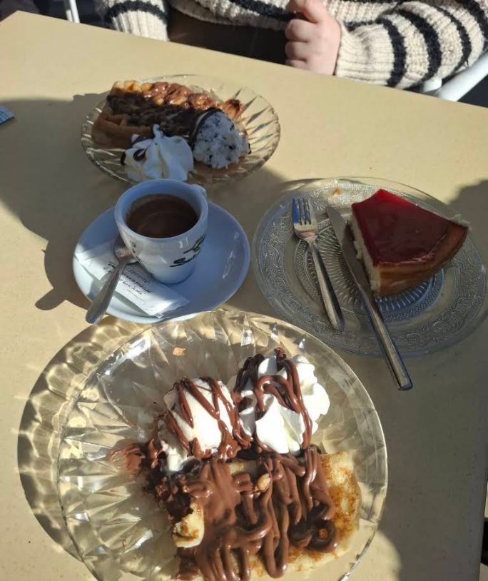 Café, crepe con chocolate y tarta de queso en la terraza